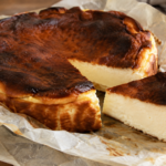 tarta de queso vasca ligera con superficie oscura y quemada, corte mostrando el interior cremoso